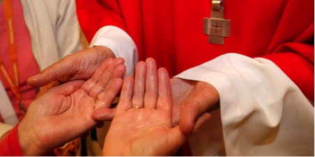 Bishop anointing hands